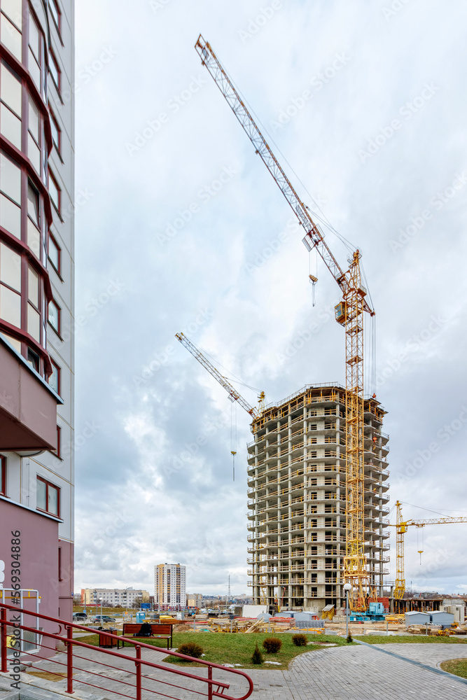 Crane and building under construction against blue sky