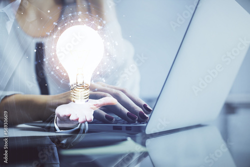 Double exposure of woman hands typing on computer and light bulb drawing. Idea concept.