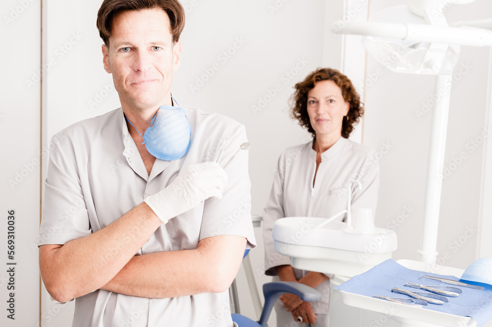 Fototapeta premium Dentists portrait in uniform standing in dentist office looking at camera 