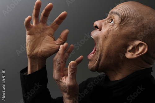 man screaming and shouting with anger on grey background with people stock photo   © herlanzer