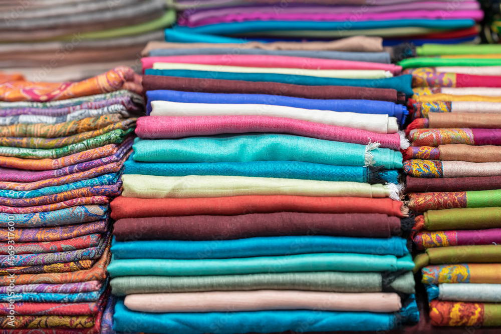 Retail place, retail display. Multicolored fabric scarves, shawls, stoles, real store shelf Retail place, retail display. Multicolored fabric scarves, shawls, stoles, real store shelf