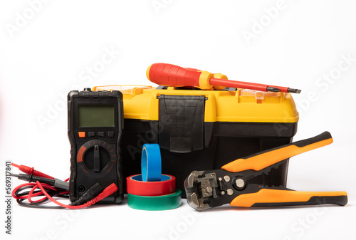 Toolbox isolated on white background.Box with electrician's tools. Multimeter, construction tape, electrical tape, screwdrivers, pliers and an automatic insulation stripper.