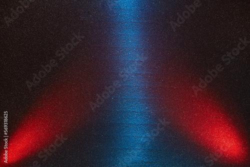 On a dark  finely grained background  central blue and lateral red rays of light