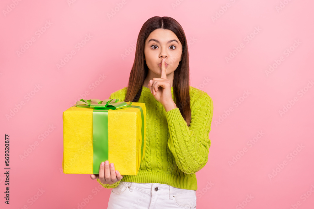 Photo portrait of pretty young schoolgirl finger touch lips secret present dressed stylish green clothes isolated on pink color background Photo portrait of pretty young schoolgirl finger touch lips secret present dressed stylish green clothes isolated on pink color background
