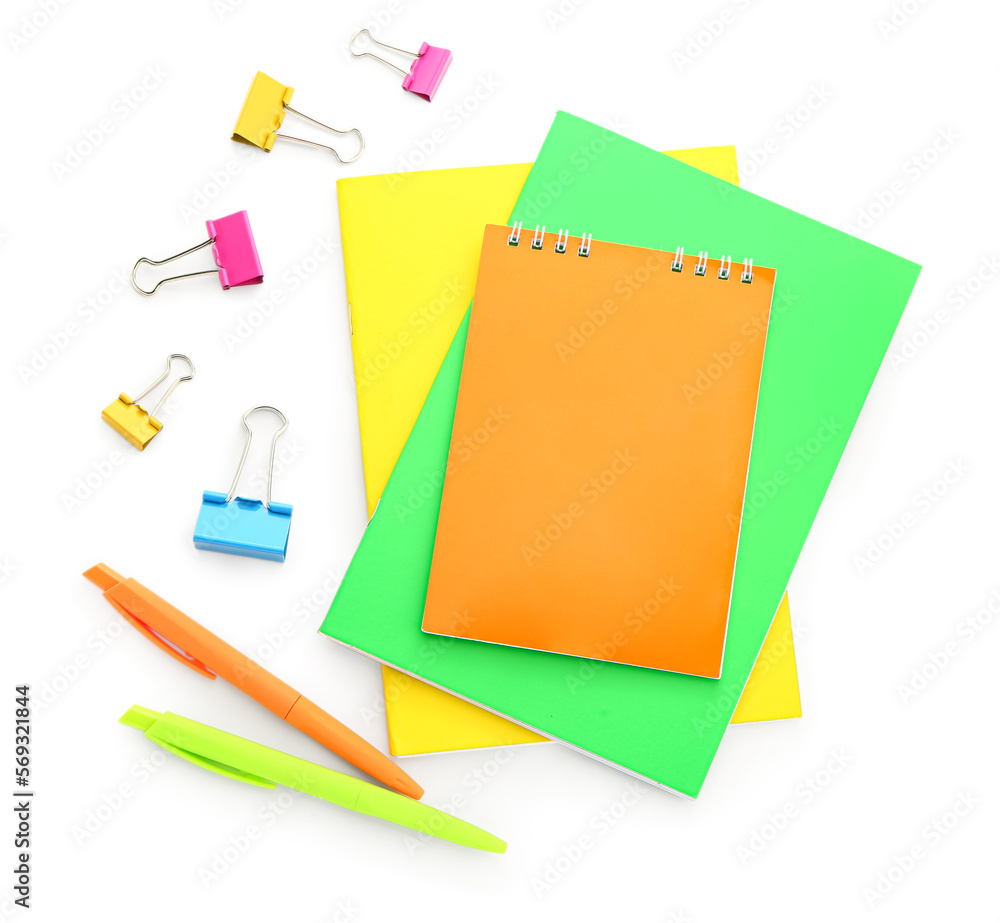 Colorful notebooks, paper clips and pens on white background Colorful notebooks, paper clips and pens on white background