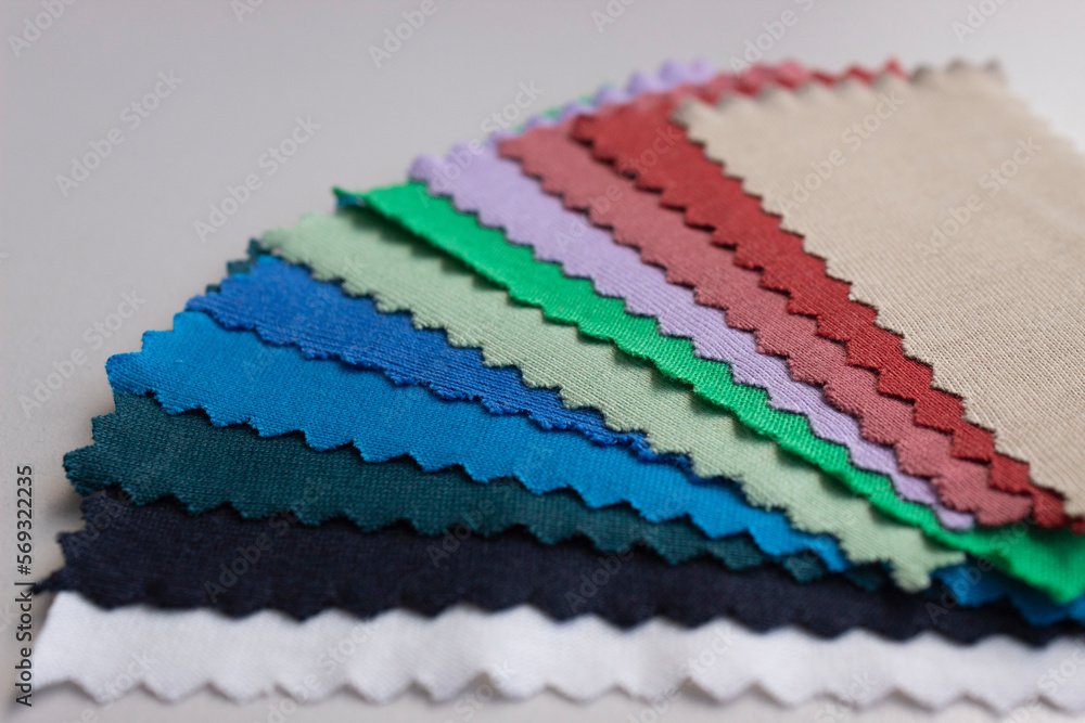 Close up to a cloth color samples over a white table 