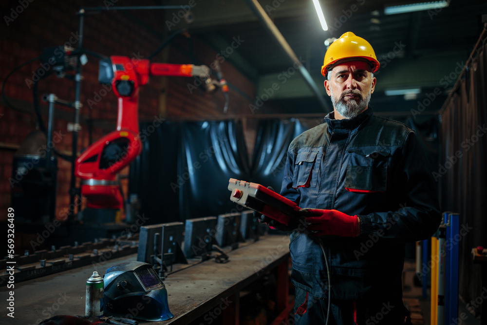 Portrait of engineer with robotic welder and copy-space. Portrait of engineer with robotic welder and copy-space.