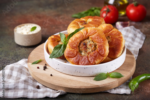 Peremech or belyash pies from yeast dough with grounded meat.  Street food. Savory snack. Delicious homemade appetizer. Open pie and filling is visible in the middle.
