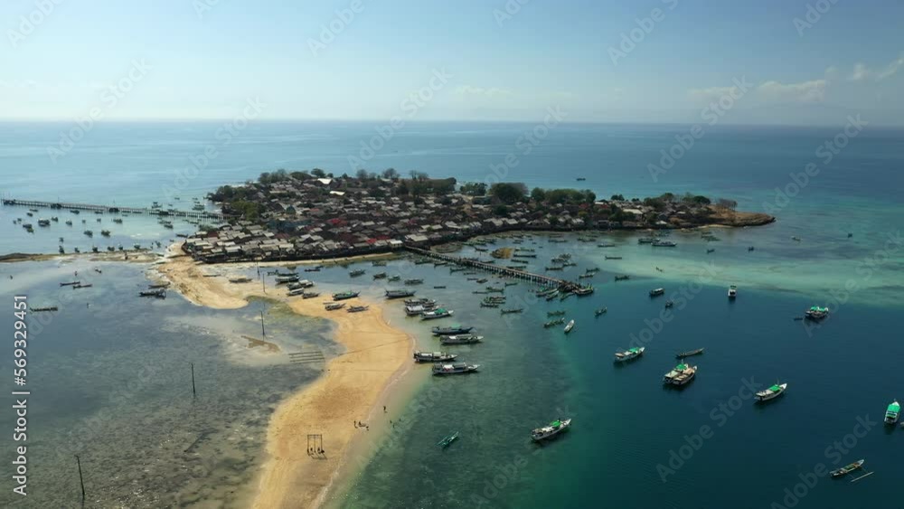 Aerial Shot Of Small Houses On Island Under Sky, Drone Flying Backwards Over Sea - Lombok, Indonesia Aerial Shot Of Small Houses On Island Under Sky, Drone Flying Backwards Over Sea - Lombok, Indonesia
