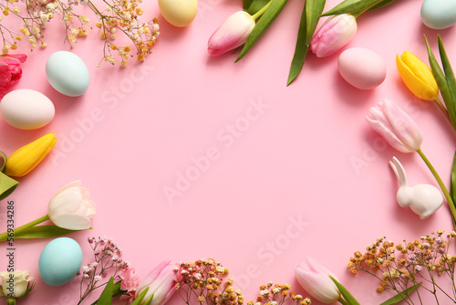 Frame made of Easter eggs and beautiful flowers on pink background