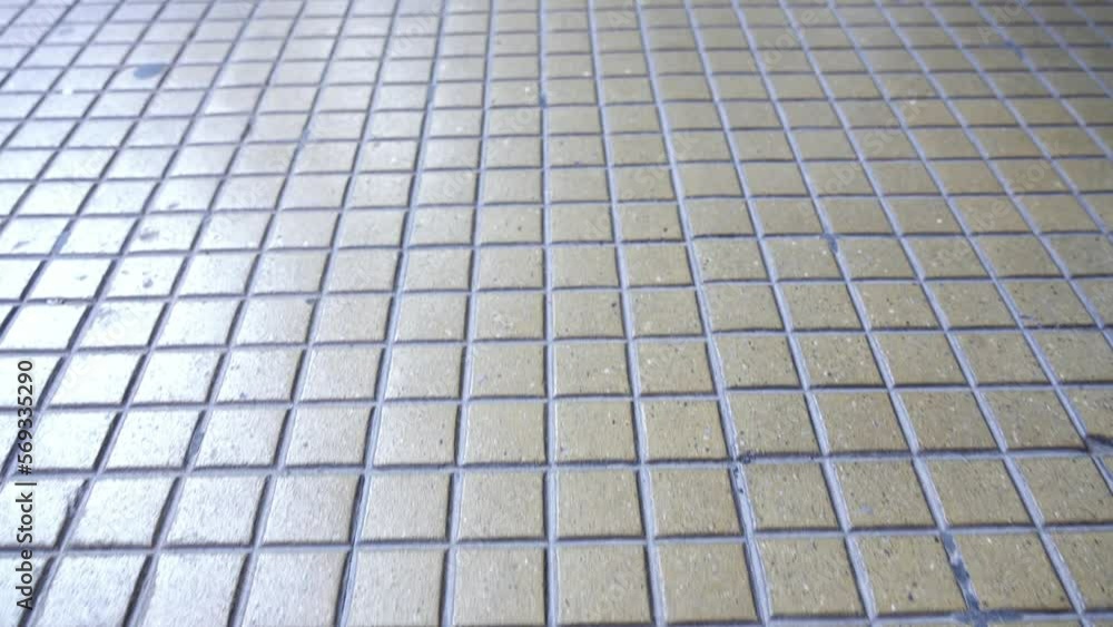 Designed brown pavement located on city centre historical square reflects bright sunlight on sunny day close back motion Designed brown pavement located on city centre historical square reflects bright sunlight on sunny day close back motion