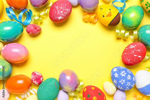 Frame made of painted Easter eggs and serpentine on yellow background