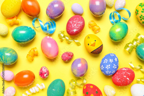 Composition with painted Easter eggs and serpentine on yellow background