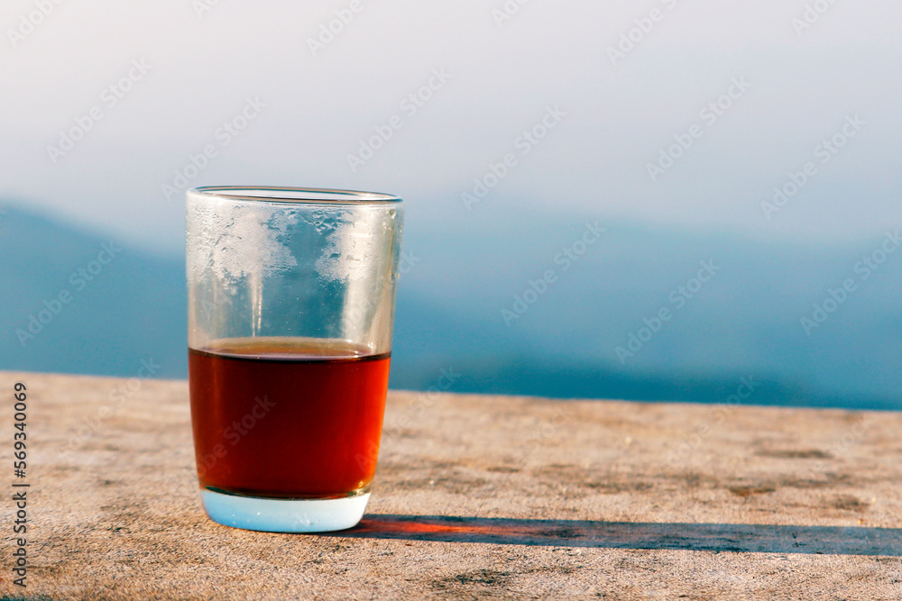 black tea in transparent glass cup isolated with blue sky