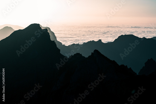 Pico do Arieiro is the third highest peak on Madeira Island and is one of the most popular sunrise spots.,a view from a drone of a landscape shrouded in clouds photo