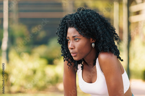 Cuadro en lienzo retrato de mujer negra con ropa deportiva, preparándose para hacer ejercicios, descansando y respirando al aire libre con luz natural