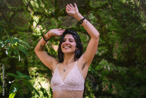 Happy young woman showing her armpit hair in the nature photo