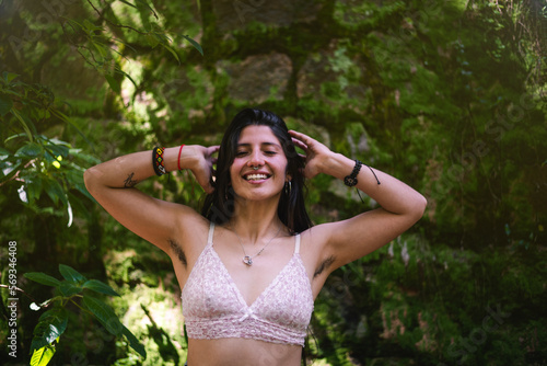 Unshaven happy young woman showing her armpit hair in the nature