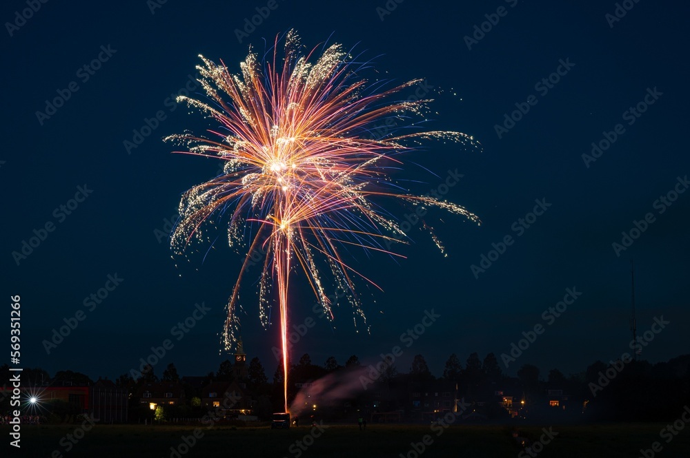 Colorful ornamental fireworks are set off from a field