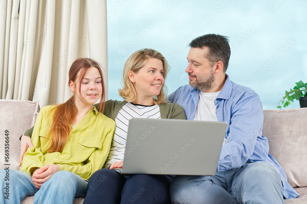Happy Family on couch using gadget. Watching something online on computer together with family. Rest at home. Happy Family on couch using gadget. Watching something online on computer together with family. Rest at home.