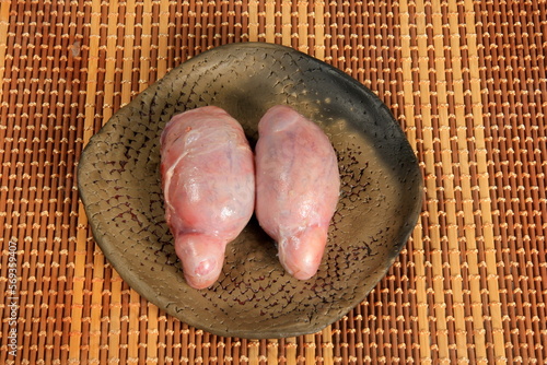 Raw bull testicles on clay plate