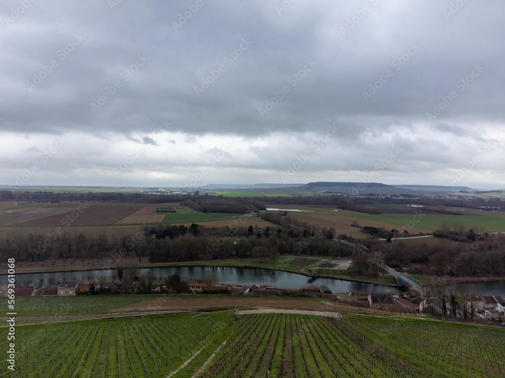 Aerial panoramic winter view on cloudy landscape, hilly vineyards and Marne river near Ay gran cru champagne village, wine production in France Aerial panoramic winter view on cloudy landscape, hilly vineyards and Marne river near Ay gran cru champagne village, wine production in France