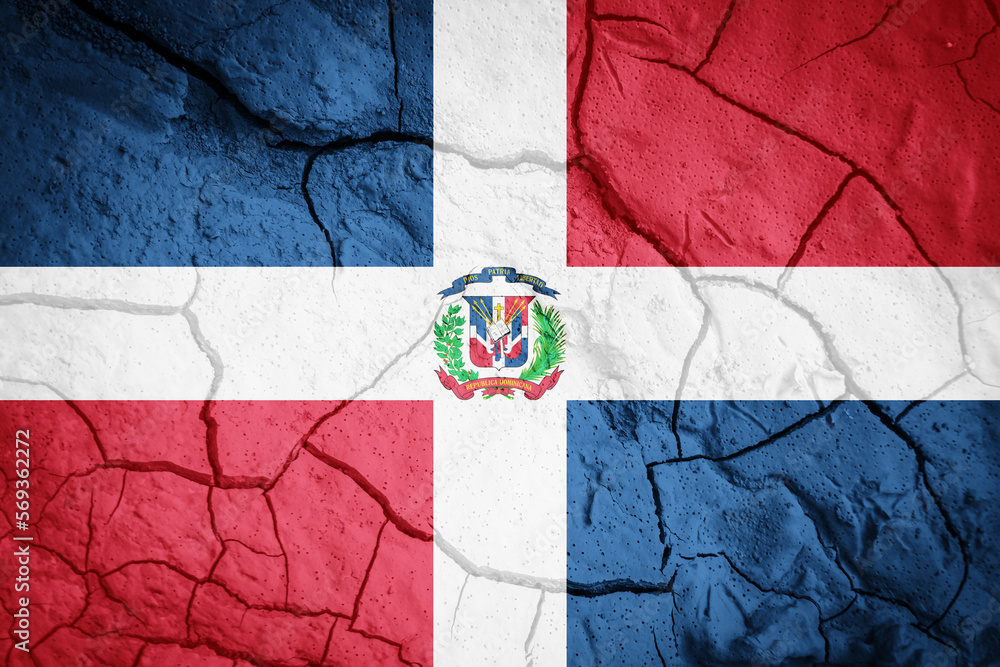 Flag of Dominican Republic. Dominican Republic symbol. Flag on the background of dry cracked earth. Dominican Republic flag with drought concept