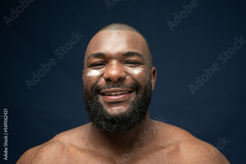 African Handsome bearded Skincare smiling facing camera