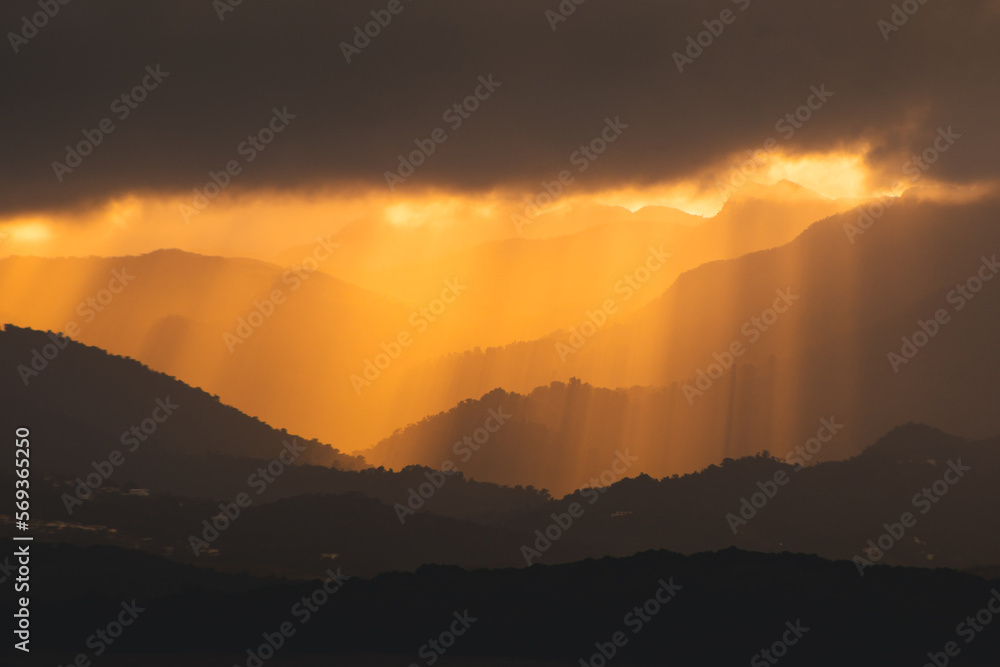 Beautiful minimalist golden hour mountain landscape with sun rays and a big cloud above Beautiful minimalist golden hour mountain landscape with sun rays and a big cloud above