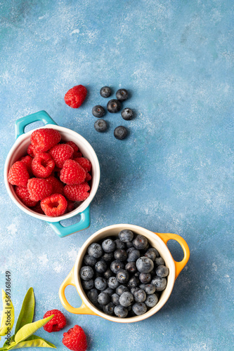 Fresh berries. Blueberry and raspberry in ceramic bowls. Colourful fruit, food background, top view.