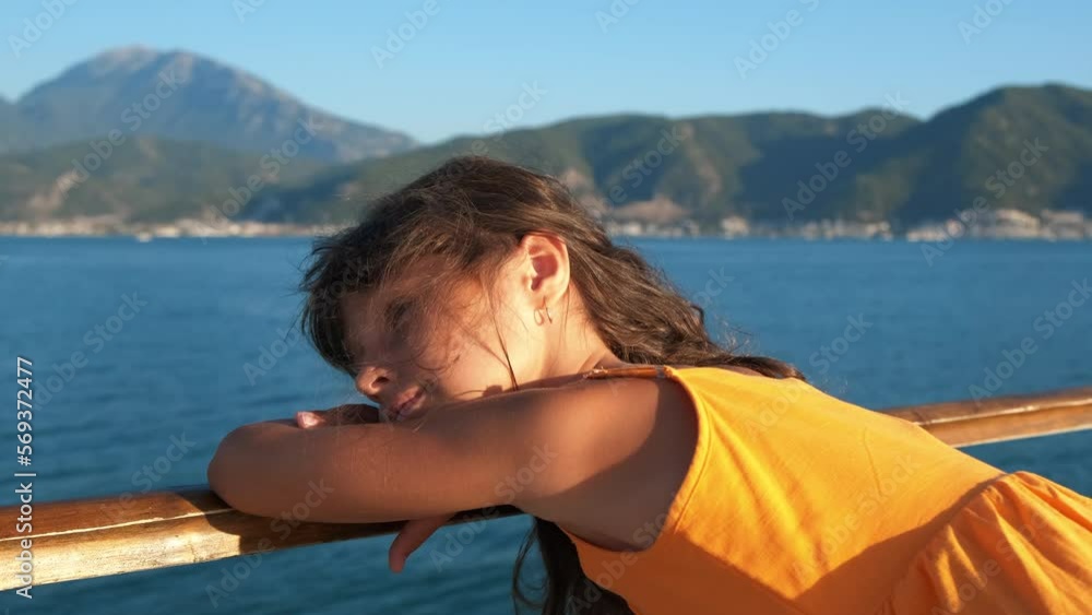 Sea relax on backdrop of high mountains. A smiling little girl like her summer emotions on the pier in summer. Sea relax on backdrop of high mountains. A smiling little girl like her summer emotions on the pier in summer.