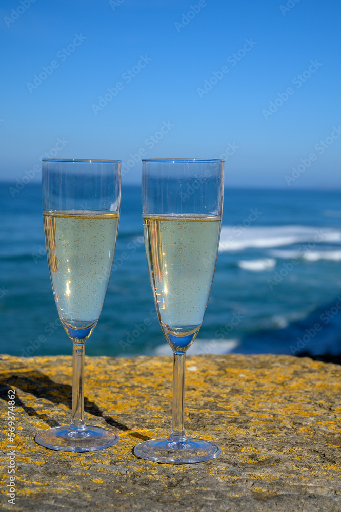 Glasses of champagne sparkling wine and view on blue Atlantic ocean, Lisbon area, Portugal Glasses of champagne sparkling wine and view on blue Atlantic ocean, Lisbon area, Portugal