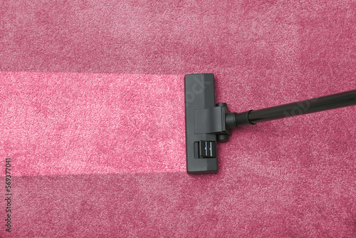 Vacuuming dirty pink carpet. Clean area after using device, top view