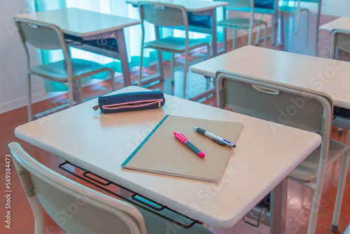 教室の机の上に置かれたノートとペン、ペンケース。学校生活のイメージ、背景素材