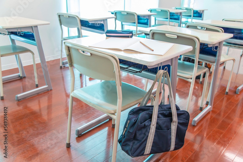教室の机に吊り下げられたスクールバック。学校生活のイメージ、背景素材