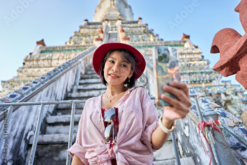 happy thai woman taking seflie at wat arun temple in bangkok thailand photo