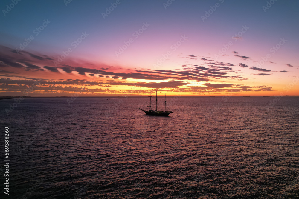 Aerial view of a sailing boat moored off the coast of Fremantle in Western Australia captured at sunset.