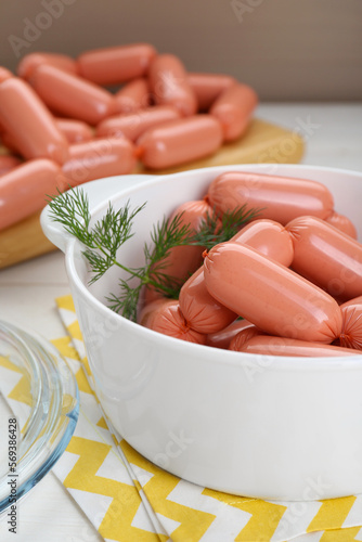 Bowl of delicious sausages and dill on white wooden table