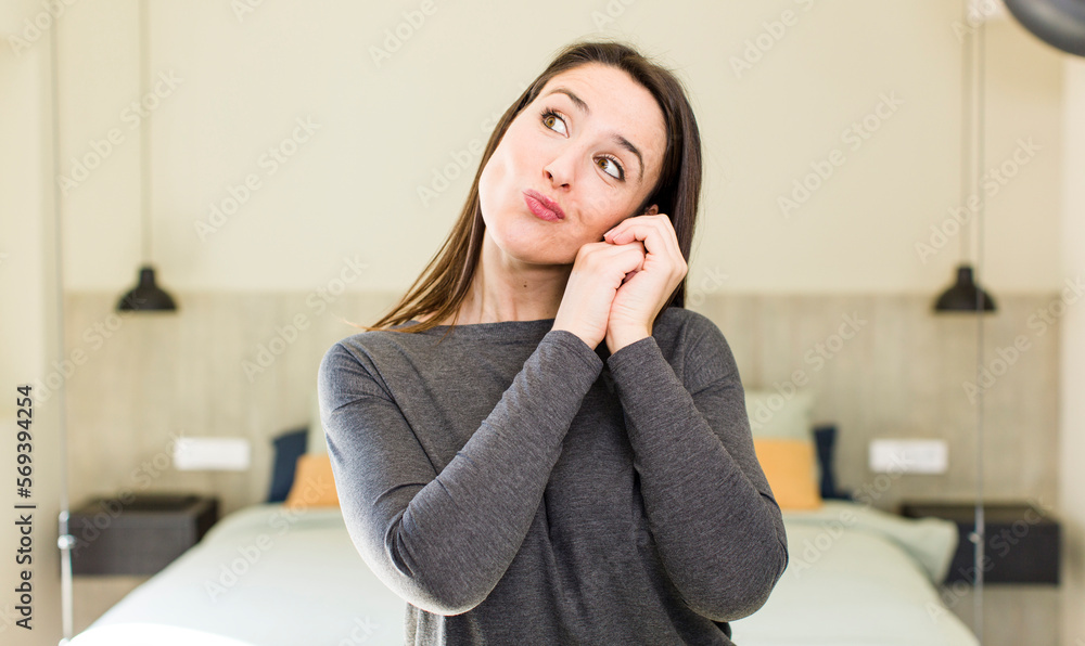 young adult pretty woman feeling in love and looking cute, adorable and happy, smiling romantically with hands next to face young adult pretty woman feeling in love and looking cute, adorable and happy, smiling romantically with hands next to face