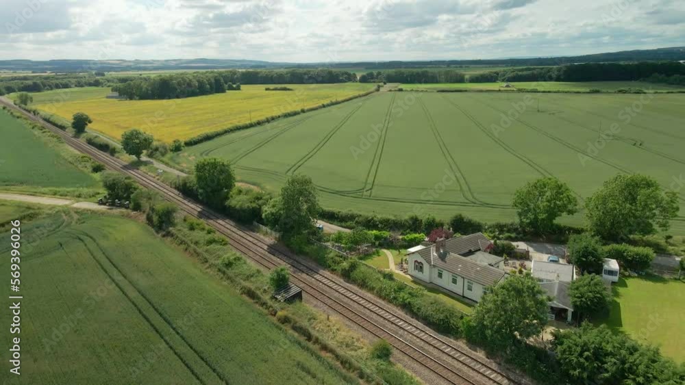 Aerial view of British rural scene with train tracks, agricultural farmland and green fields Aerial view of British rural scene with train tracks, agricultural farmland and green fields