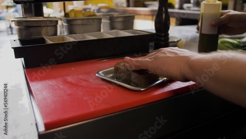 Chef lubricates tuna with oil photo