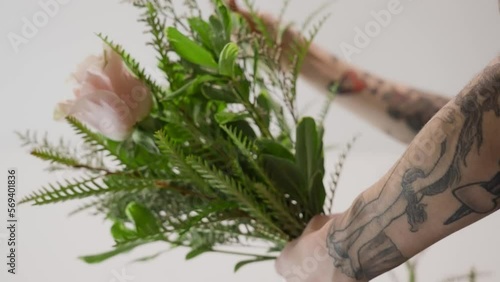 Holding a bundle of Flowers and Greenery in an arrangement. photo