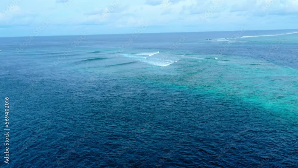 Aerial Backward Scenic View Of Blue And Turquoise Ocean Under Cloudy Sky - Thulusdhoo, Maldives Aerial Backward Scenic View Of Blue And Turquoise Ocean Under Cloudy Sky - Thulusdhoo, Maldives