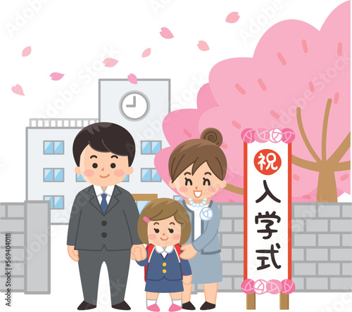 入学式の看板の前に立つ女子小学生と保護者