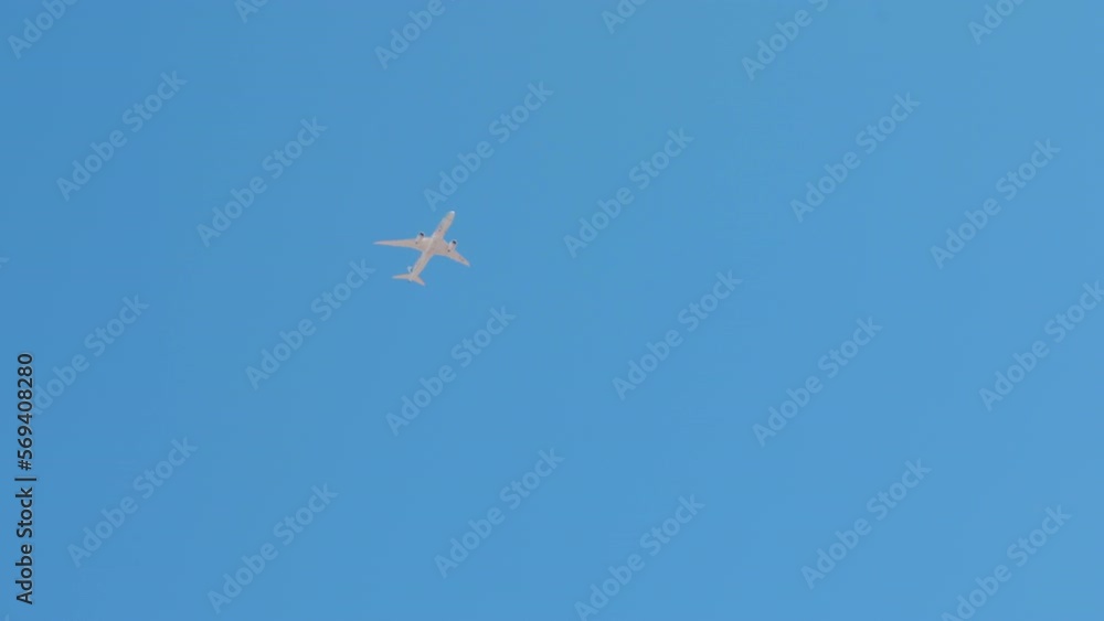 Eagle passing at cloudless sky with white airplane flying. Bottom view of aircraft outdoors in sunshine on sunny spring summer day Eagle passing at cloudless sky with white airplane flying. Bottom view of aircraft outdoors in sunshine on sunny spring summer day