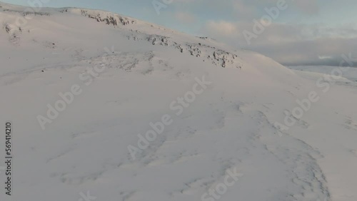 Snowed mountain side and beautiful oceanshore. Dolly forward, tilt up  photo