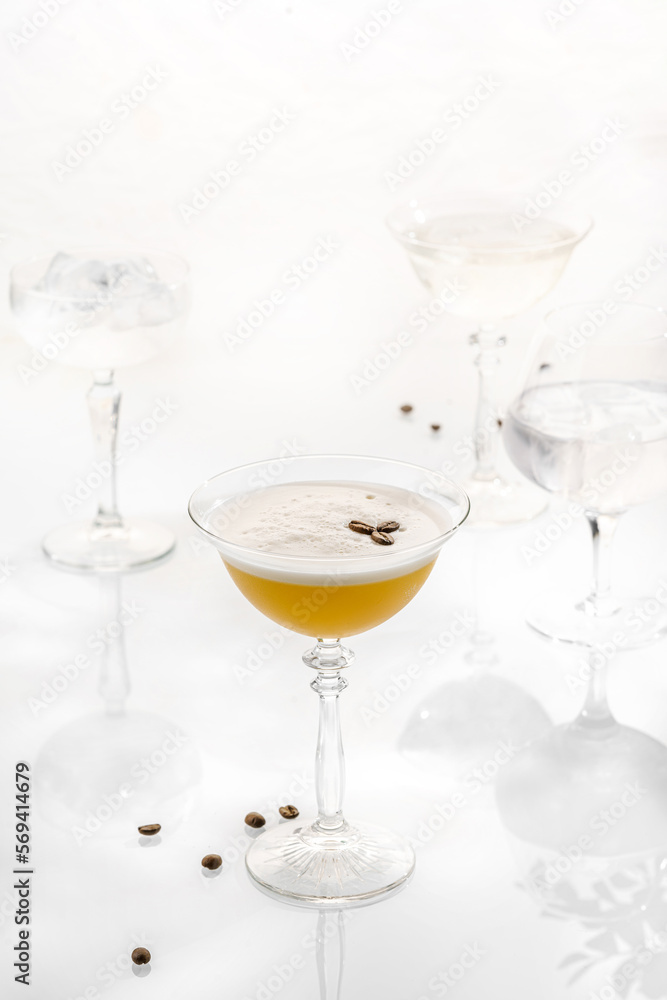 Cocktail mix in glass on white background with alcohol, coffee beans peel foam martini espresso