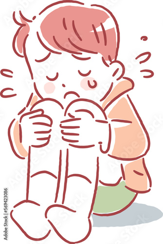 涙を流しながら膝を抱えてなく男の子