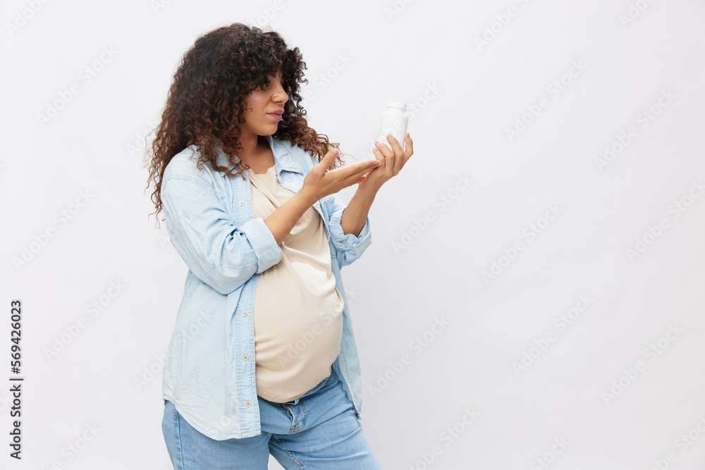 Pregnant woman smile with teeth jar of pregnancy vitamin pills in hands, alpha lipoic acid, vitamin complex on white isolated background copy space, free background Pregnant woman smile with teeth jar of pregnancy vitamin pills in hands, alpha lipoic acid, vitamin complex on white isolated background copy space, free background