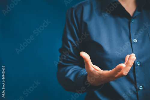 Closeup of businesswoman hand on empty dark blue background in office for design work, insert icon bundle or business technology symbols or other. selective focus on hand. female online working